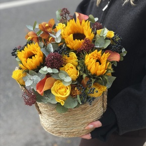Композиция в сумке "Тональность" из подсолнухов, калл, ягод вибирнума, лимонных роз, скиммии и орхидеи в Подольске