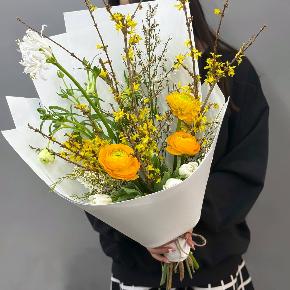 Весенний букет с желтыми ранункулюсами и цветущими ветками форзиции в Подольске